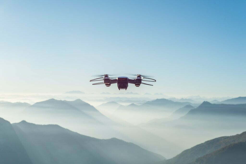 A drone soars over misty mountains